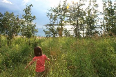 Rear view of woman on field against sky