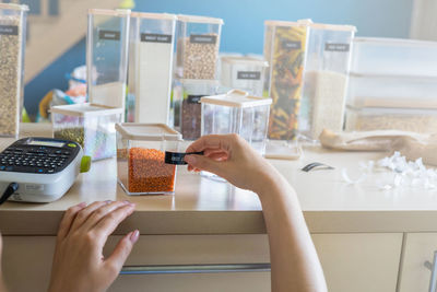 Cropped hands of woman labeling container