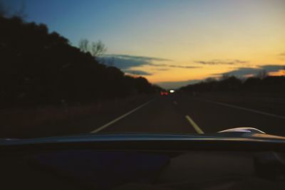 Car on road against sky during sunset