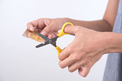 Close-up of man holding hands against white background