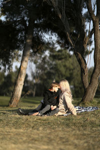 Side view of woman sitting on field