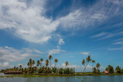 Boathouse in backwaters against cloudy sky