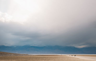 Scenic view of beach against cloudy sky