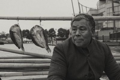 Portrait of man with fish hanging