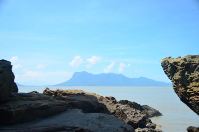 Rock formations in sea against blue sky