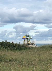 Lifeguard hut on field against sky