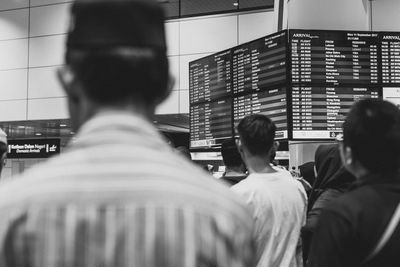 Rear view of people standing at airport