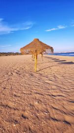 Scenic view of beach against blue sky