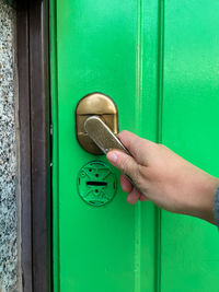 Hand opening a green door