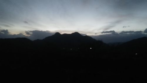 Scenic view of silhouette mountains against sky at sunset