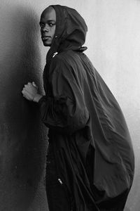 Portrait of young man standing against wall