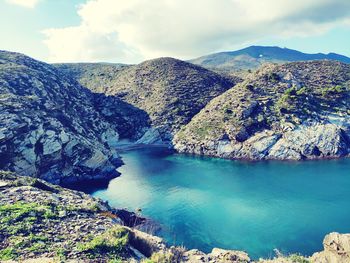 Scenic view of sea and mountains against sky