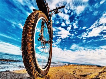 Low angle view of bicycle wheel against sky