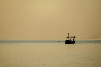 Sailboat in sea against sky during sunset