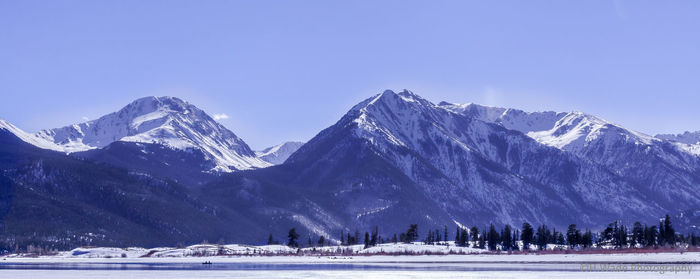 Scenic view of snowcapped mountains against clear blue sky