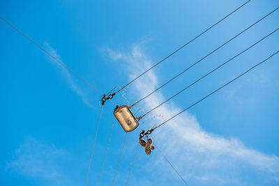 Low angle view of shoes hanging on power line against sky