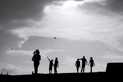 Silhouette people standing against sky