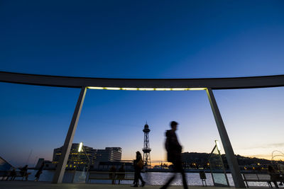 Blurred motion of people walking on pedestrian walkway at port vell