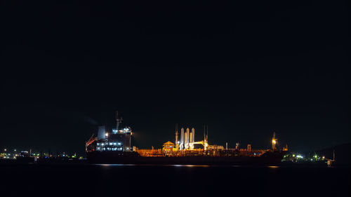 Oil ship tanker loading oil at the oil brige on the sea from refinery for transportation at night