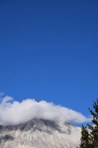 Low angle view of mountain against blue sky