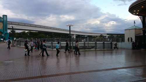 People in city against cloudy sky