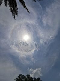 Low angle view of sunlight streaming through clouds