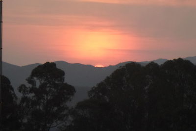 Scenic view of silhouette mountains against romantic sky at sunset