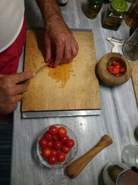 High angle view of man preparing food on cutting board