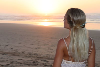 Woman enjoying at beach during sunset