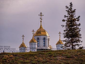 Golden domes of an orthodox church against the background of a clear blue sky.