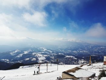 Aerial view of snowcapped mountain against cloudy sky