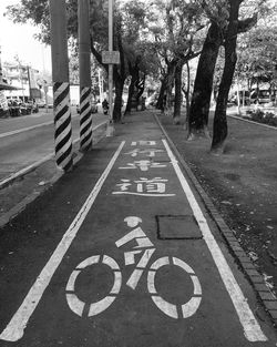 Sign on bicycle lane amidst trees