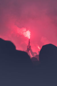 Silhouette of communications tower at night