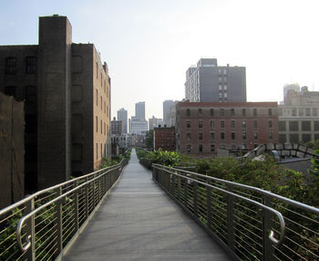 Bridge over buildings in city against sky