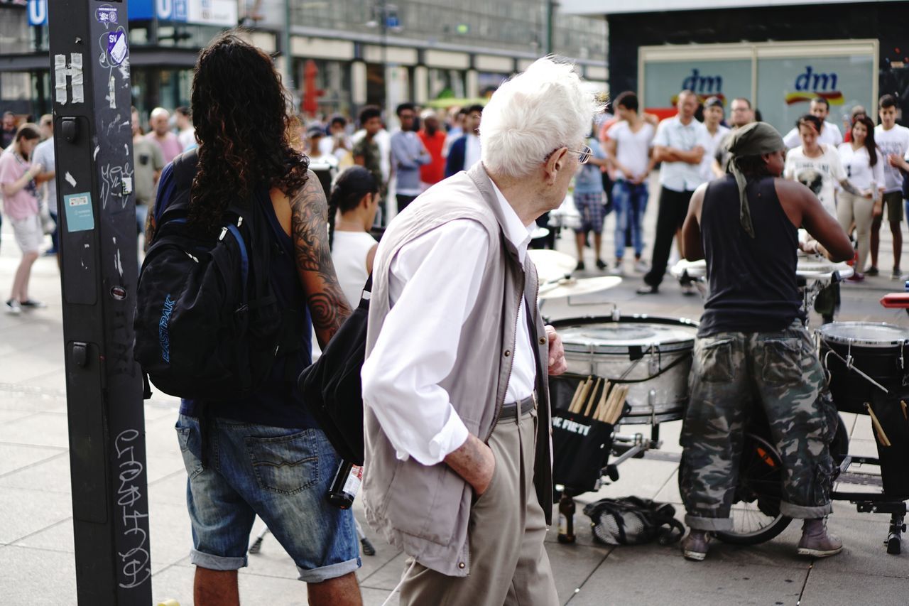 men, full length, large group of people, person, standing, city, group of people, casual clothing, well-dressed, crowd, day, outdoors, mask - disguise, focus on foreground, city life, history