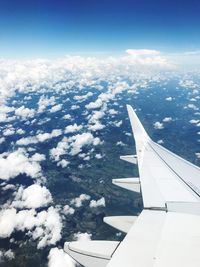 Aerial view of airplane wing over clouds