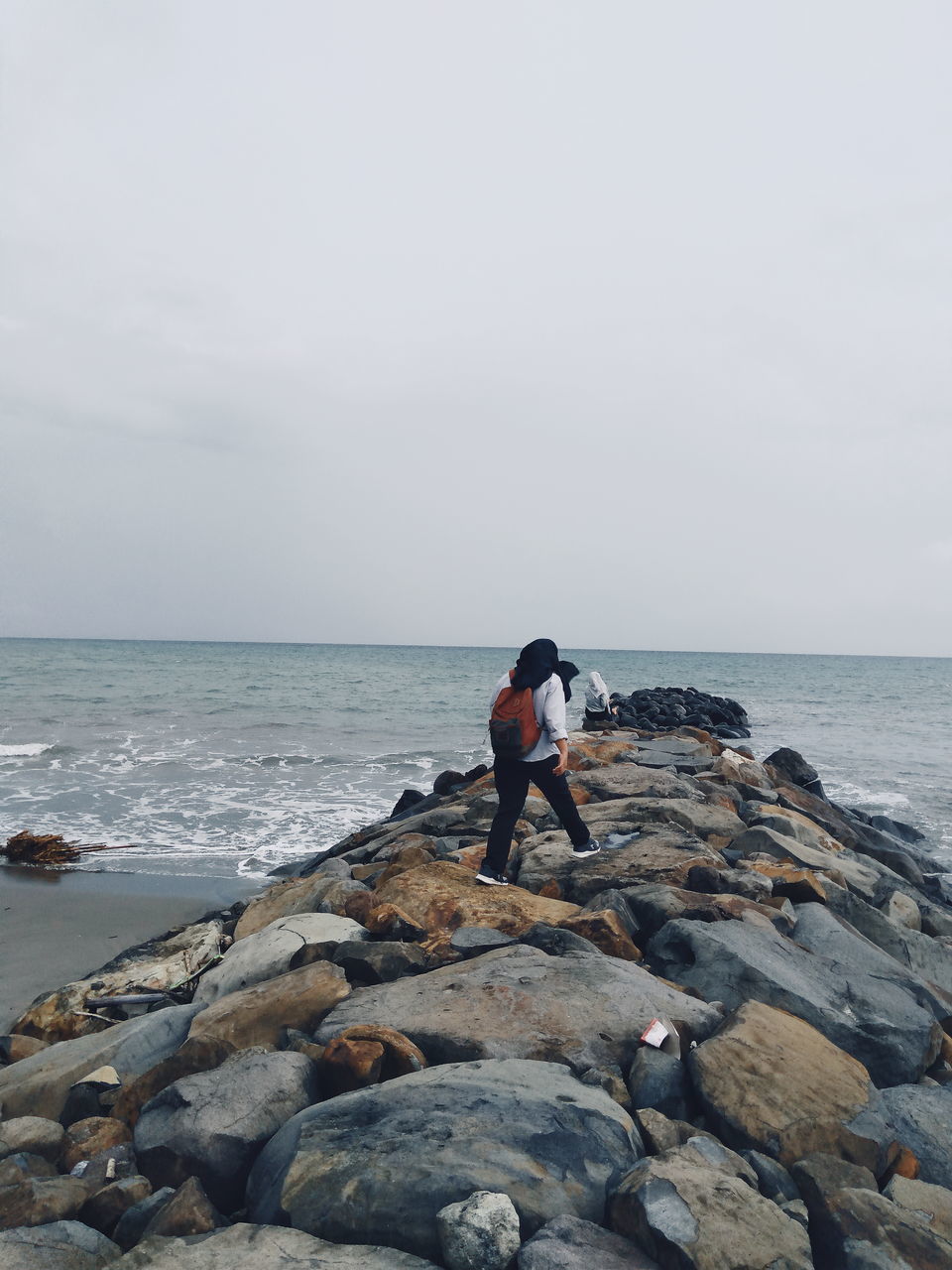 FULL LENGTH OF MAN ON ROCK AT BEACH