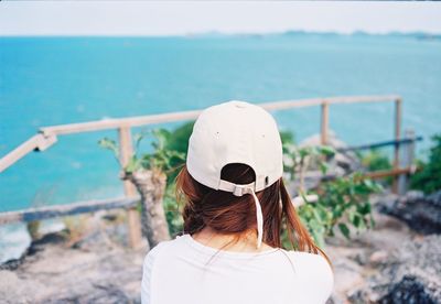 Rear view of woman standing by sea