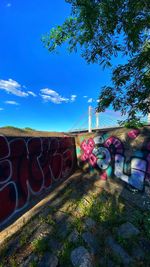 Graffiti on bridge against blue sky