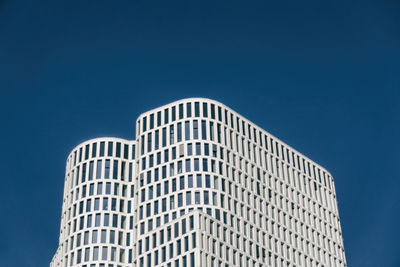 Low angle view of modern building against clear blue sky