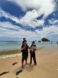 Full length of family standing on beach