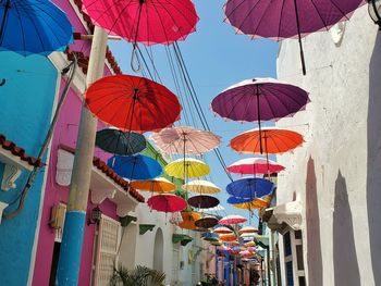 Low angle view of multi colored umbrellas hanging by building against sky in cartagena,  colombia 