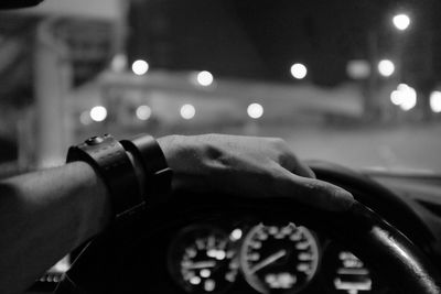 Cropped image of hand driving car at night