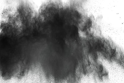 Defocused image of black powder paints against white background