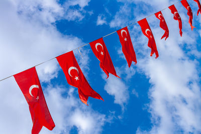 Low angle view of flags hanging against sky