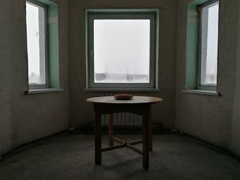 Empty chairs and table in abandoned room