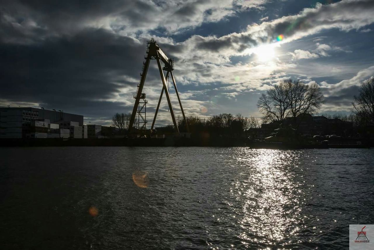 water, sky, cloud - sky, waterfront, cloudy, silhouette, cloud, built structure, sunset, architecture, crane - construction machinery, building exterior, harbor, nature, river, nautical vessel, reflection, rippled, commercial dock, beauty in nature