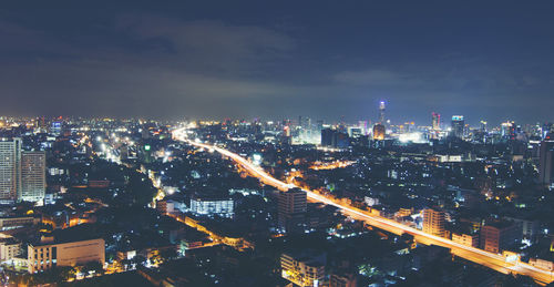 High angle view of illuminated cityscape against sky at night