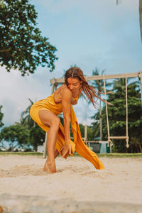 Portrait of young woman dancing on beach