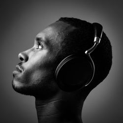 Side view of a young man over black background